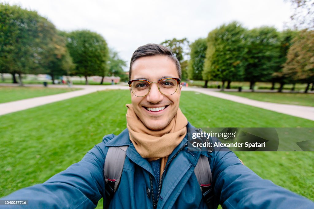 Selfie of a young man in eyeglasses in a park