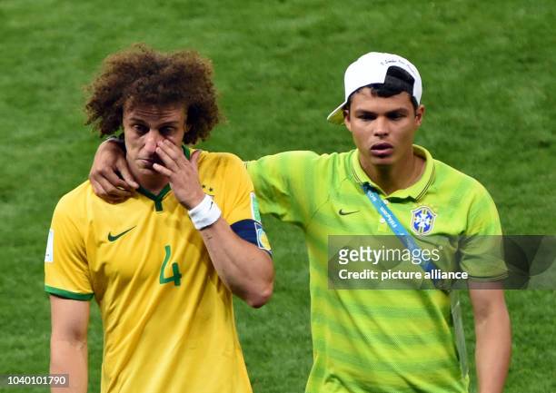 Thiago Silva of Brazil and David Luiz react after the FIFA World Cup 2014 semi-final soccer match between Brazil and Germany at Estadio Mineirao in...