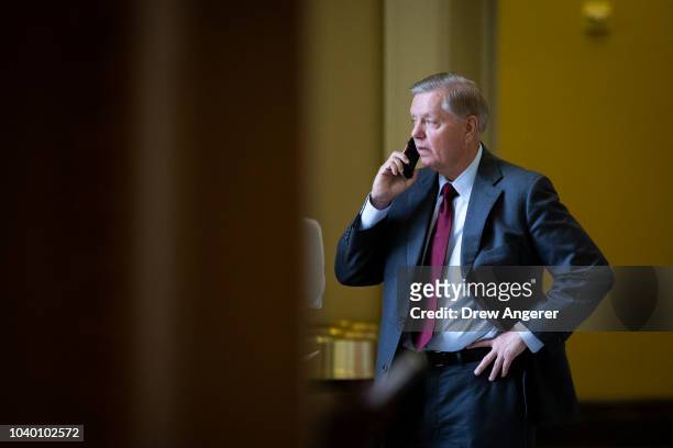 Sen. Lindsey Graham talks on his phone before the weekly GOP policy luncheon on Capitol Hill, September 25, 2018 in Washington, DC. Christine Blasey...