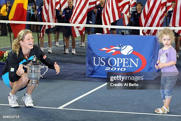 Kim Clijsters of Belgium holds the championship trophy as she is joined by her daughter Jada after defeating Vera Zvonareva of Russia during their...