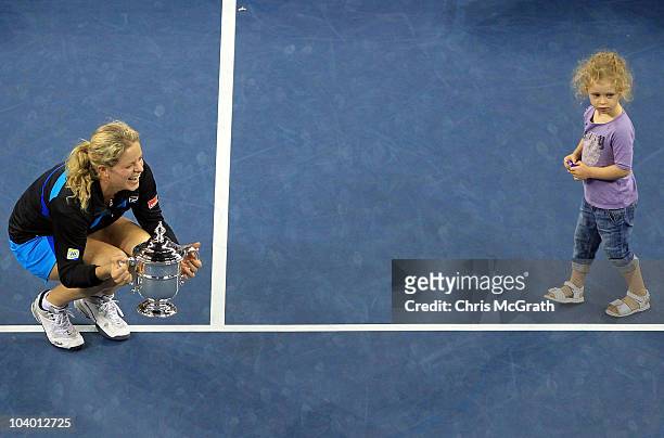Kim Clijsters of Belgium holds the championship trophy as she is joined by her daughter Jada after Clijsters defeated Vera Zvonareva of Russia during...