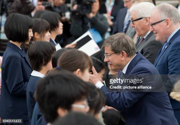 Turkish Foreign Minister Ahmed Davutoglu speaks to Japanese children next to the cenotaph of the memorial for the victims of the atomic bombing in...