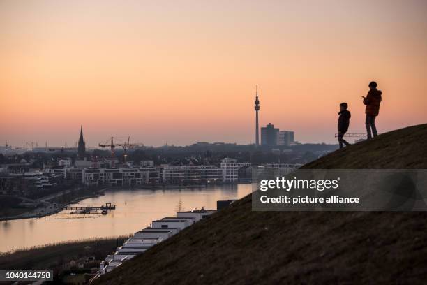 Two children watch the sun set over the city of Dortmund, Germany, 26 January 2017. Photo: Bernd Thissen/dpa | usage worldwide