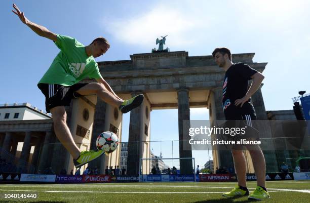 Two freestyle soccer players play with a ball during the opening of the Fan Festival for the UEFA Champions League Finale in front of the Brandenburg...