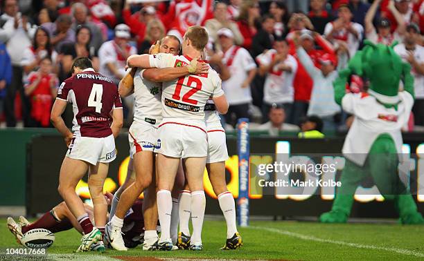Matt Cooper of the Dragons is congratulated by his team mates after he scored a try during the NRL Fourth Qualifying Final match between the St...