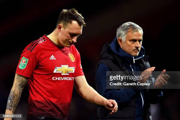 Jose Mourinho, Manager of Manchester United applauds fans as Phil Jones of Manchester United looks dejected after missing his team's eighth penalty,...