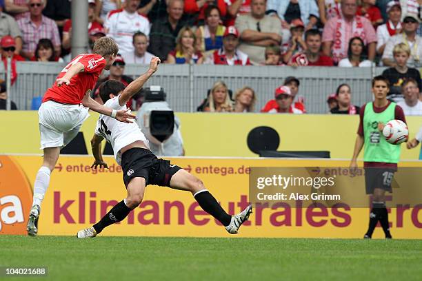 Andre Schuerrle scores his team's second goal against Florian Dick of Kaiserslautern during the Bundesliga match between FSV Mainz 05 and 1. FC...