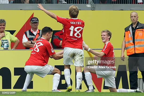 Andre Schuerrle of Mainz celebrates his team's second goal with team mates Lewis Holtby and Adam Szalai during the Bundesliga match between FSV Mainz...