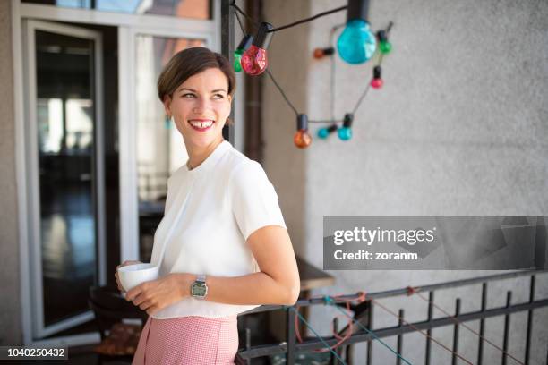 mujer disfrutando de café en el balcón en lugar de trabajo - hueco entre dientes fotografías e imágenes de stock