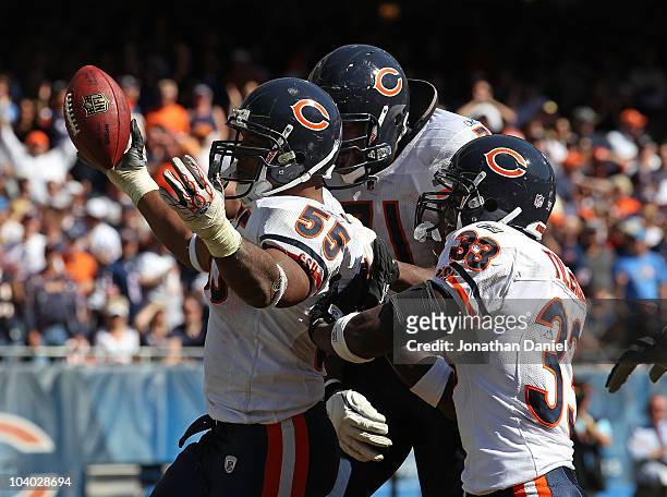 Lance Briggs of the Chicago Bears celebrates a turn-over with teammates Israel Idonije and Charles Tillman during the NFL season opening game against...