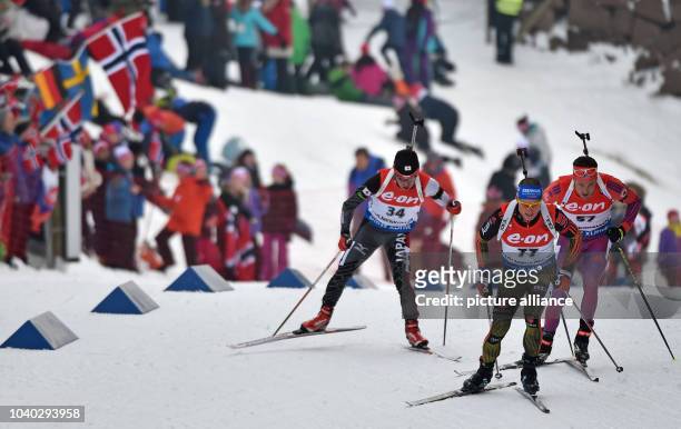 Yuki Nakajima of Japan, Erik Lesser of Germany and Tim Burke of USA in action during the men's 20km individual competition at the Biathlon World...