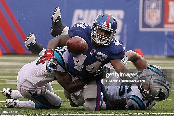 Ahmad Bradshaw of the New York Giants loses the ball in a tackle by Richard Marshall and Greg Hardy of the Carolina Panthers during the NFL season...