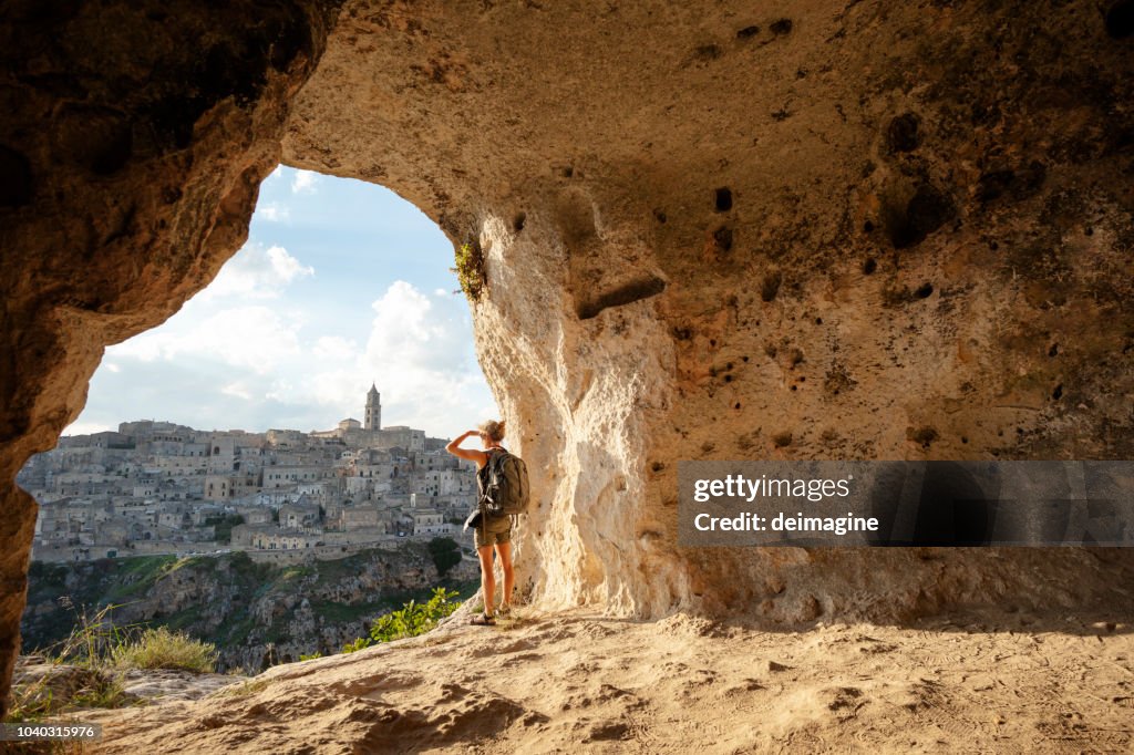 Donna che guarda la vista da una grotta di Matera, Basilicata, Italia
