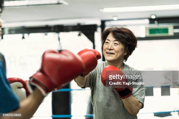 seniors femmes adultes, formation avec instructeur masculin au gymnase de boxe - boxning sport photos et images de collection