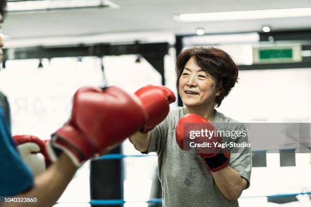 mulheres adultas sênior de treinamento com instrutor masculino no ginásio de boxe - sports training - fotografias e filmes do acervo