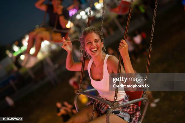 happy young couple on carousel in amusement park - luna park stock pictures, royalty-free photos & images