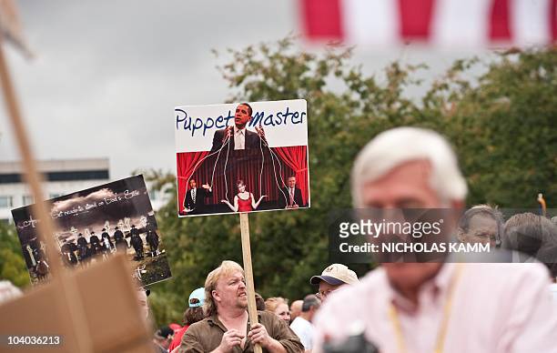 Demonstrator carries a sign depicting US President Barack Obama as a puppet master in front of the US Capitol during a march of supporters of the...