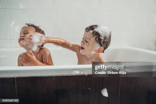 brüder spielen in der badewanne - brothers bathroom stock-fotos und bilder