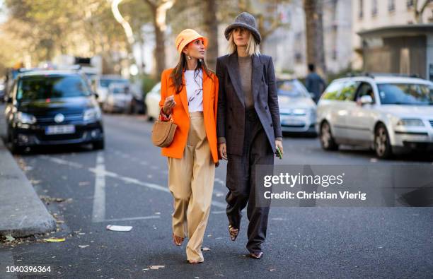 Linda Tol wearing grey hat and Chloe Harrouche wearing Prada bucket hat and orange blazer is seen outside Koche during Paris Fashion Week Womenswear...