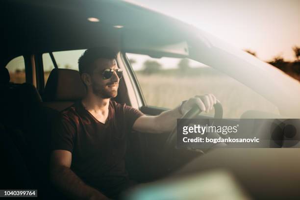man driving in sunset - car interieur stock pictures, royalty-free photos & images