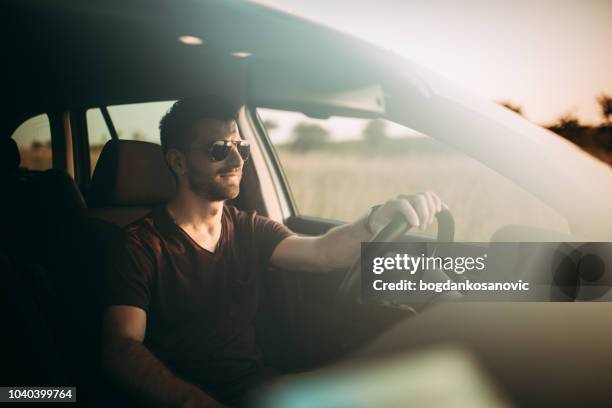 man driving in sunset - driving imagens e fotografias de stock