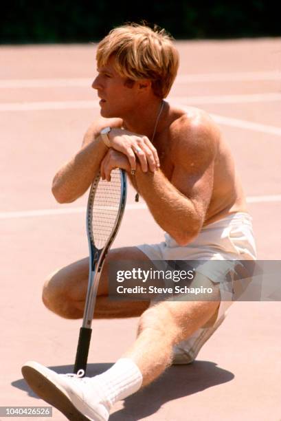 View of American actor Robert Redford as he sits on a tennis court in a scene from the film 'The Way We Were' , Los Angeles, California, 1972.