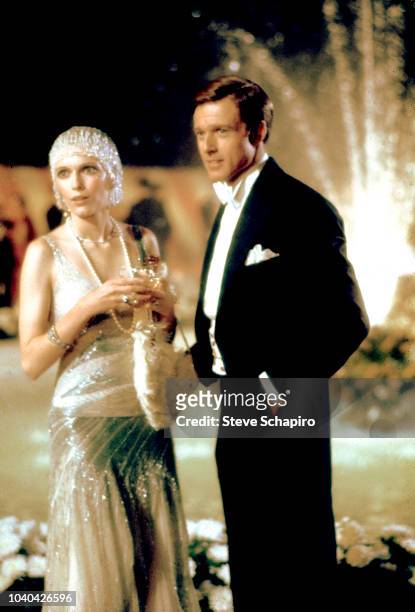 View of American actors Mia Farrow and Robert Redford, both in formal attire, in a scene from the film 'The Great Gatsby' , Newport, Rhode Island,...