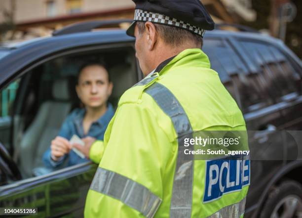 police man giving a speeding ticket - criminal justice imagens e fotografias de stock