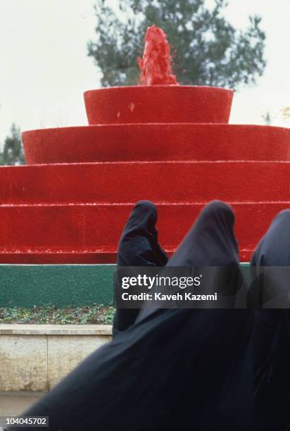 Families at the Behesth-e Zahra cemetery in Tehran, Iran, 1st February 1984. In the background is a fountain of red liquid representing the blood of...