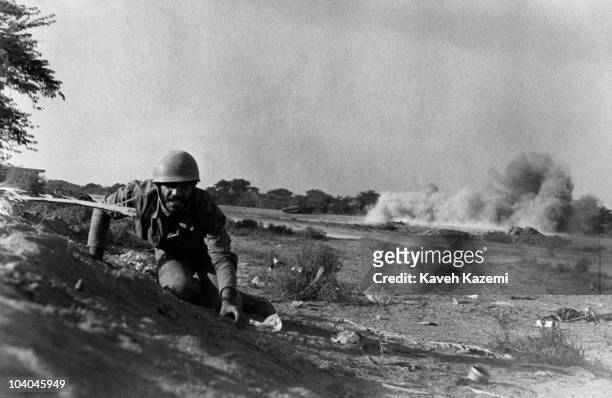 An Iranian soldier keeps low during heavy shelling by Iraqi artillery on the Zolfaghari front, during the Iran-Iraq War, Abadan, Iran, 10th December...