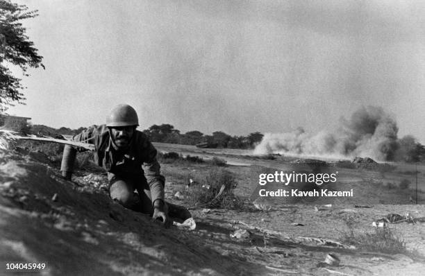 An Iranian soldier keeps low during heavy shelling by Iraqi artillery on the Zolfaghari front, during the Iran-Iraq War, Abadan, Iran, 10th December...