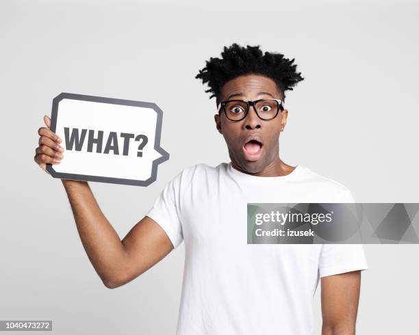 surprised afro american man holding speech bubble - manquestionmark stock pictures, royalty-free photos & images