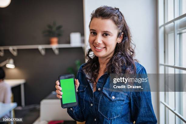 portrait of confident businesswoman holding smart phone with chroma key - showing mobile stock pictures, royalty-free photos & images