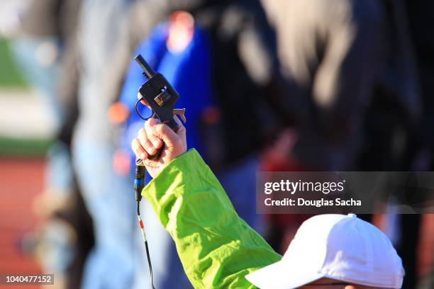 race referee prepares to start the race with a shot from the starters pistol - pistola de salida fotografías e imágenes de stock