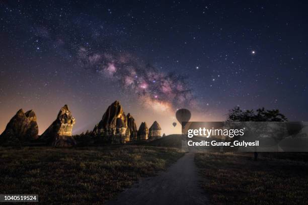 cheminées de fées avec la voie lactée et de montgolfières à cappadocia, goreme, turquie - cheminée de fée photos et images de collection