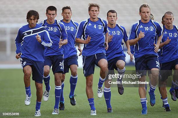 Raul Gonzalez , Benedikt Howedes and Ivan Rakitic of Schalke lead the warm up during the FC Schalke Training session, ahead of their Group B UEFA...