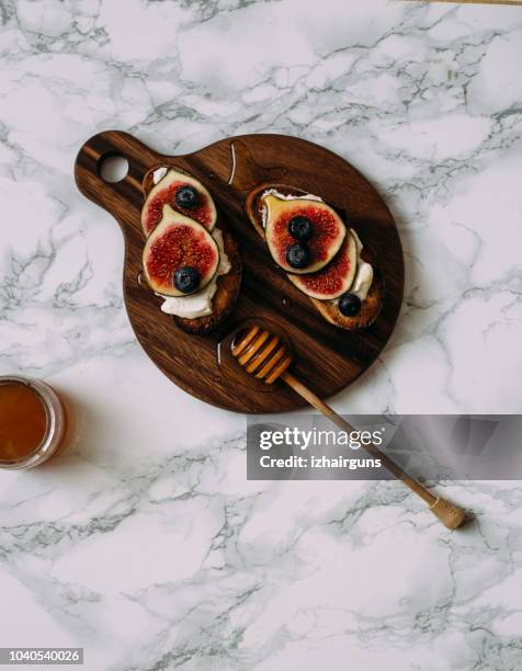 grill toast with honey, cream cheese or ricotta and fresh ripe figs on cutting board. - ricotta stock pictures, royalty-free photos & images