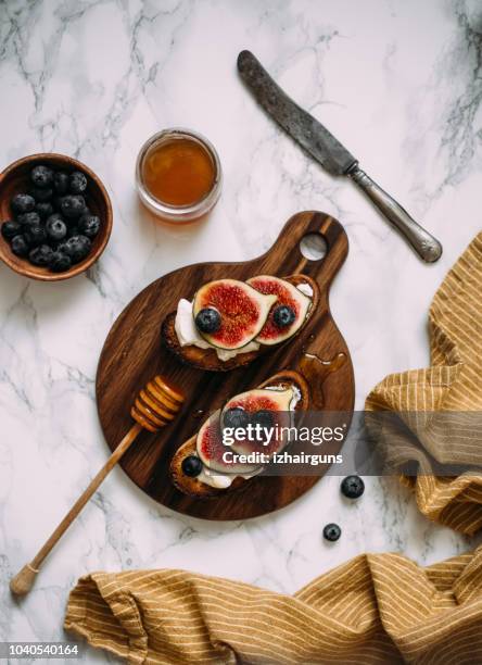 grill toast with honey, cream cheese or ricotta and fresh ripe figs on cutting board. - ricotta stock pictures, royalty-free photos & images