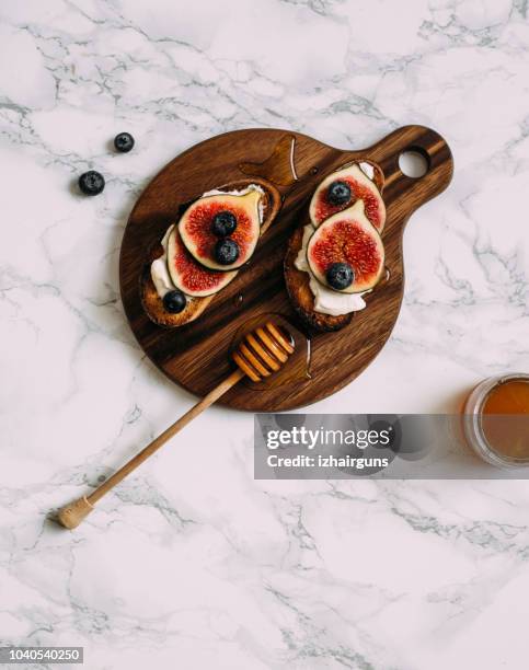 grill toast with honey, cream cheese or ricotta and fresh ripe figs on cutting board. - ricotta cheese stock pictures, royalty-free photos & images
