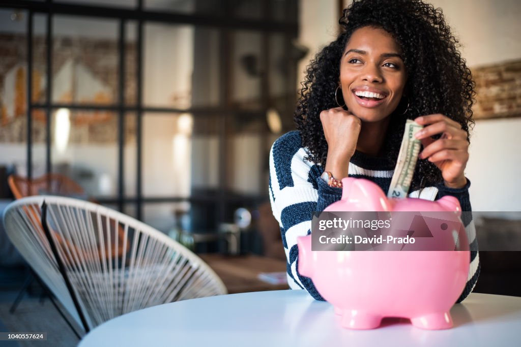 Black woman with saving piggy bank