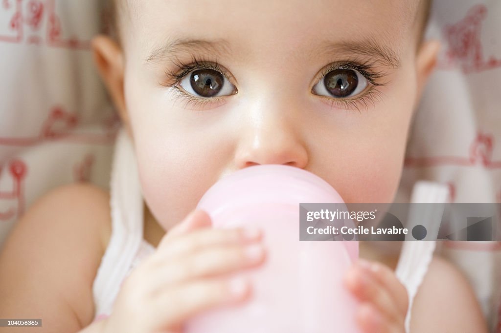 Baby girl drinking from bottle