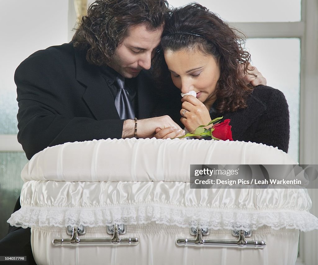 Grieving Couple With Infant's Coffin