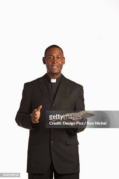 a man wearing a clerical collar and preaching from the bible - cuello clerical fotografías e imágenes de stock