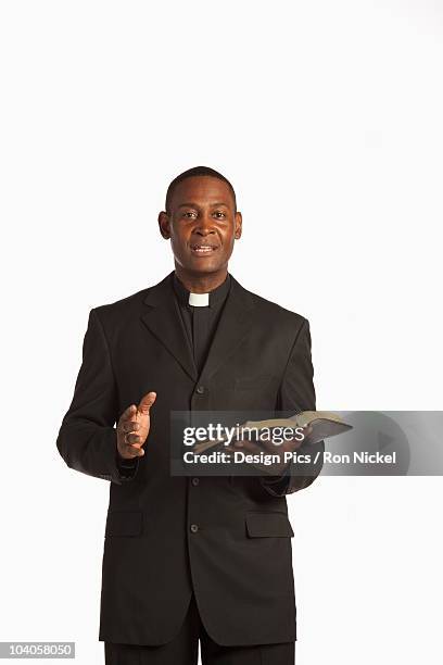 a man wearing a clerical collar and preaching from the bible - priest collar stock pictures, royalty-free photos & images