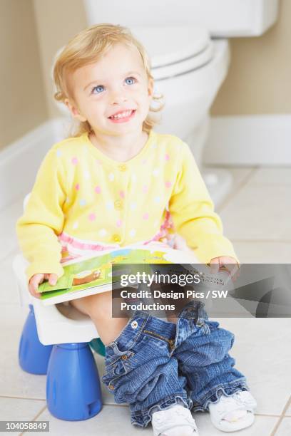 a young child sitting on a child's potty and reading a book - knoxville girls stock pictures, royalty-free photos & images