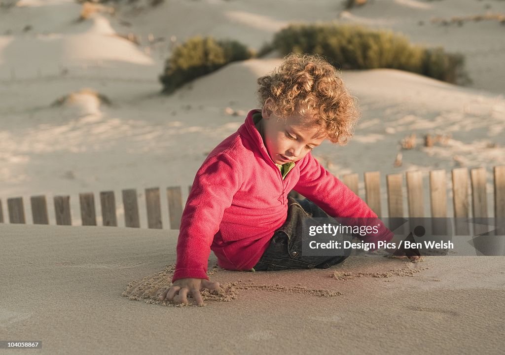 A Young Boy Playing On A Sand Dune
