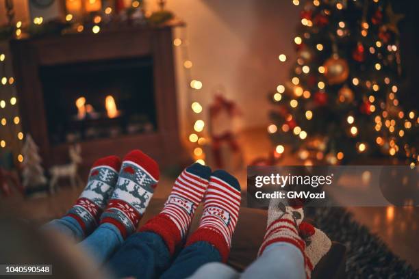 mignons petits enfants en chaussettes de noël assis dans une ambiance chaleureuse de noël - chaussette photos et images de collection