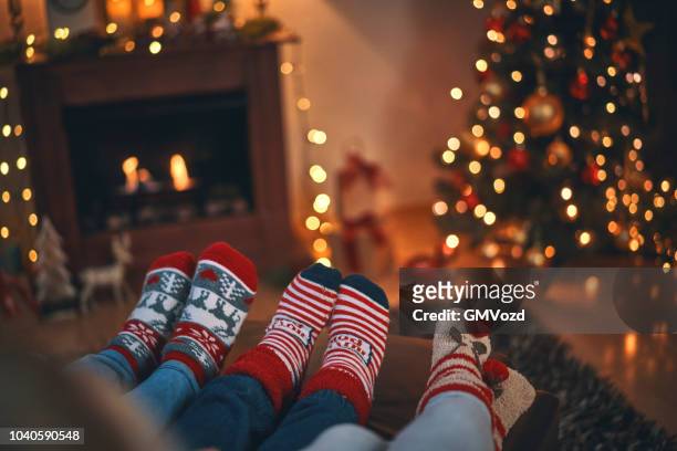bambini carini in calze natalizie seduti in un'accogliente atmosfera natalizia - calza della befana foto e immagini stock