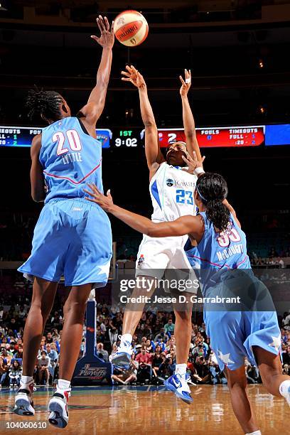 Cappie Pondexter of the New York Liberty shoots under pressure against Sancho Lyttle and Angel McCoughtry of the Atlanta Dream in Game One of the...