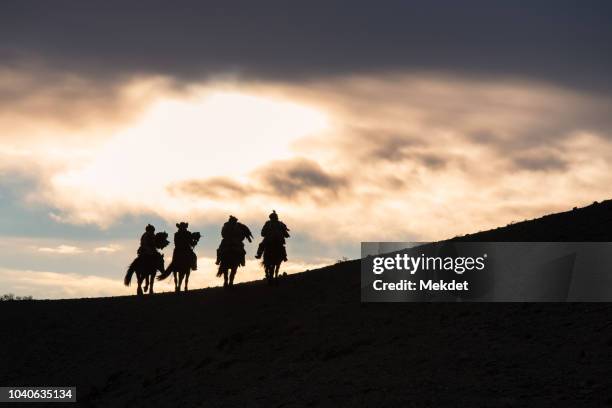 the silhouette photo of kazakhs people riding horse, bayan-ölgii, mongolia. - wanderer stock pictures, royalty-free photos & images